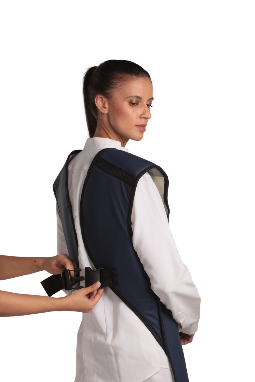 A partial back view of a female model wearing a navy blue, beige-lined coat apron with flex back. The paracord buckle is open and being fastened onto her back.