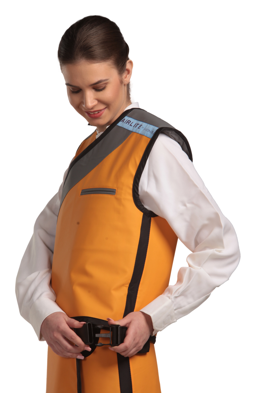 Side view of a female model wearing a tangerine radiation protection skirt and vest. The vest is tangerine with grey lines around the left edge and paracord buckles that fastens by the side.