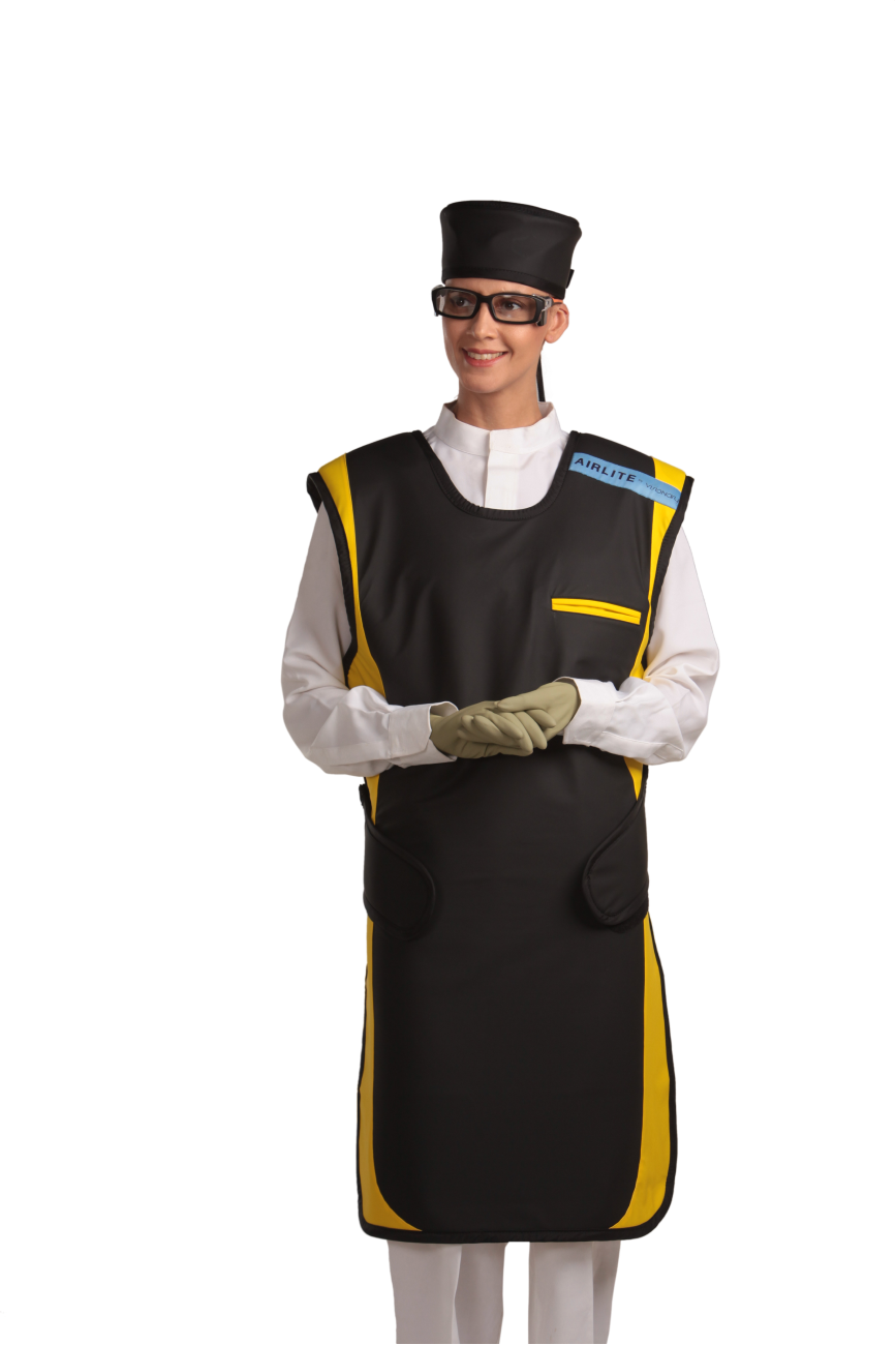 A full frontal view of a female model wearing a black, yellow-lined coat apron with flex back, a black head shield, and a protective eyewear. Her hands are clasped below her chest.