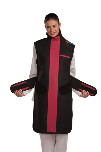 Ankle-length frontal view of a female model wearing a coat apron with integrated thyroid guard. The apron is Jet black with a Bordeaux red center line and has unfastened velcro fasteners held in the model's hands.