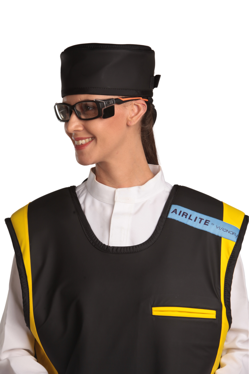 Up-close view of a female model wearing a radiation protection head shield, eyewear, and a coat apron. The apron is jet-black with yellow-colored lines by the edges.  