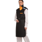 A left-side frontal view of a female model wearing a black, orange-lined coat apron with integrated thyroid guard. The apron's paracord buckles are fastened to the front. 