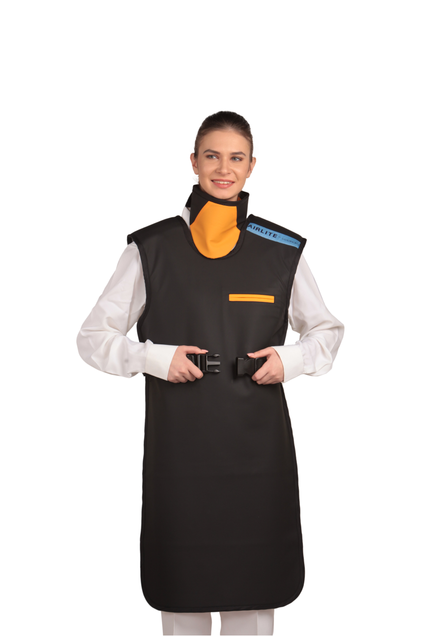 A full frontal view of a female model wearing a black, orange-lined coat apron with an integrated thyroid collar. She is about to fasten the coat apron's paracord buckles to the front.