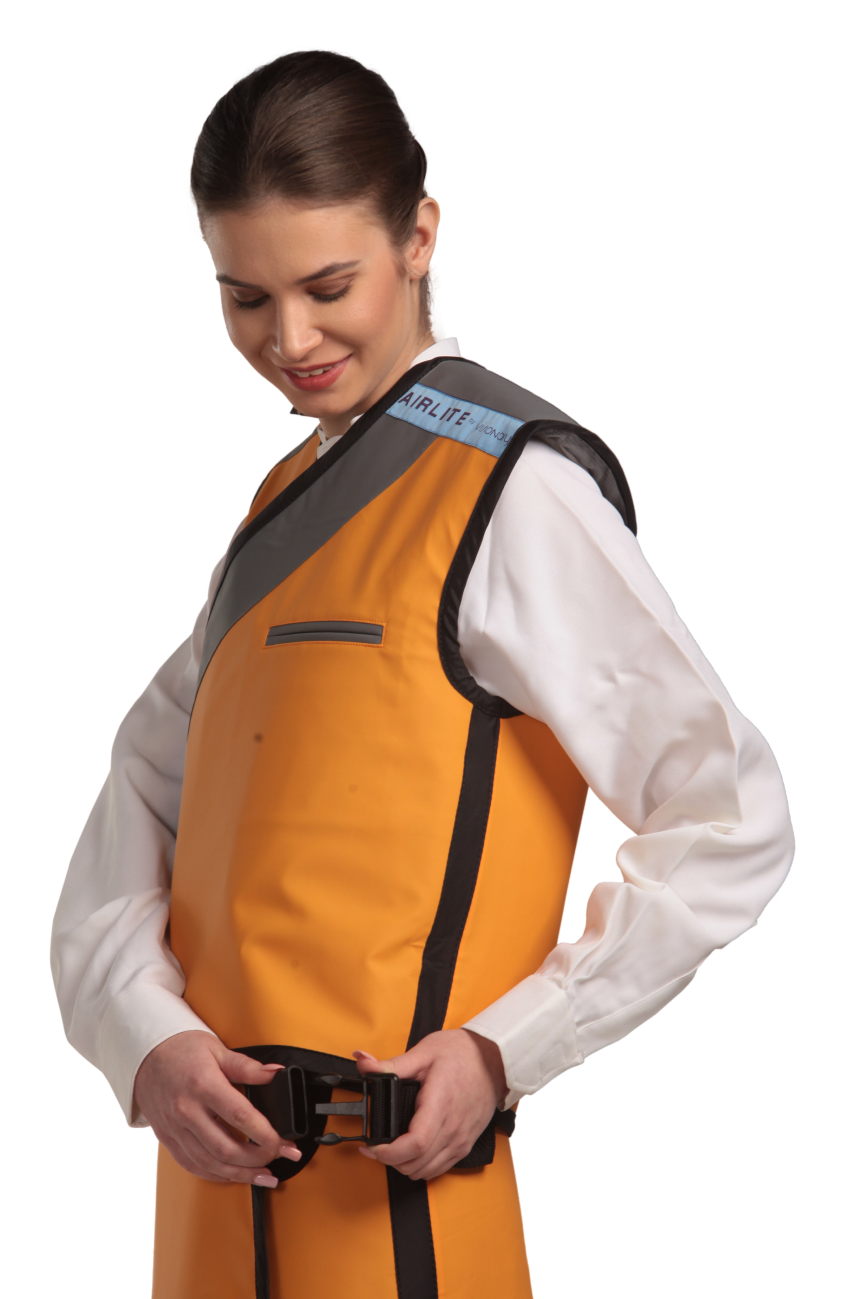 Side view of a female model wearing a tangerine radiation protection skirt and vest. The vest is tangerine with grey lines around the left edge and paracord buckles that fastens by the side. 