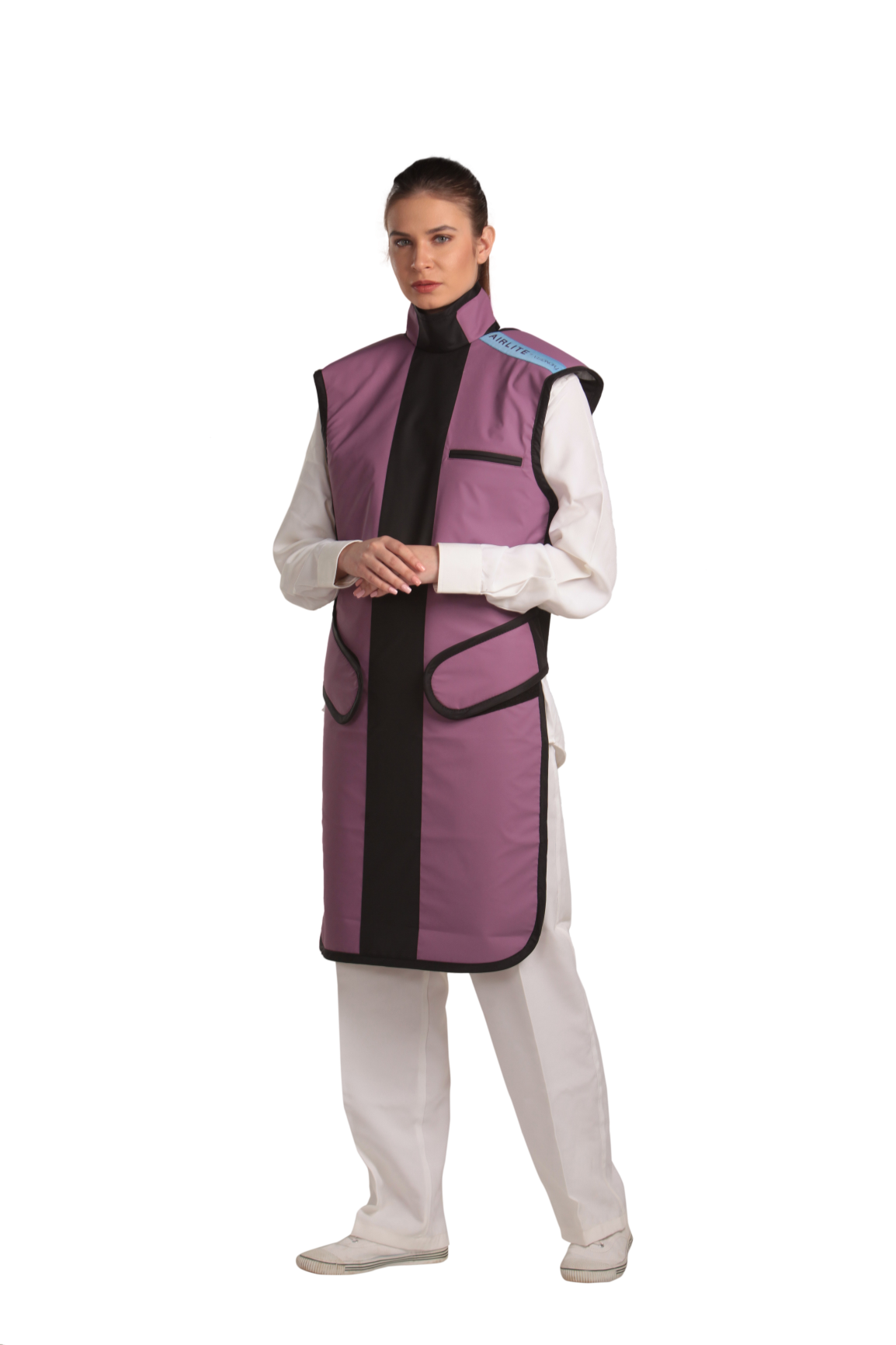 A left-side frontal view of a female model, her two hands clasped together below her chest, wearing a coat apron with an integrated thyroid guard. The apron is mauve in color with a Jet black center line and has closed velcro fasteners by the sides.