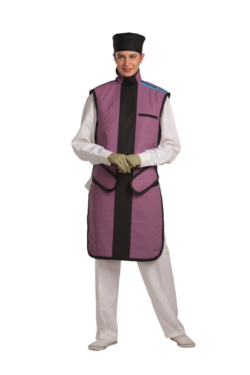 Full frontal view of a female model, her hands clasped together below her chest, wearing a radiation protection head shield, medical gloves, and a coat apron with an integrated thyroid guard. The apron is mauve with a Jet black-colored center line and has closed velcro fasteners by the sides.
